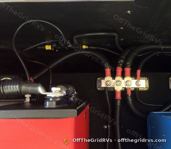 Red-capped 600A busbars with every cable run in black loom inside a Leisure Travel Vans Unity compartment