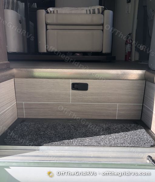 The same Leisure Travel Vans Unity entry step closed up, with no sign of the lithium battery underneath