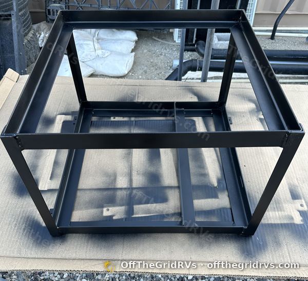 Black powder-coated steel battery rack modified in-house at OffTheGridRVs