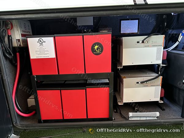 Six 320 Ah Lithionics modules on a two-tier rack beside dual inverters in a Newmar Essex bay