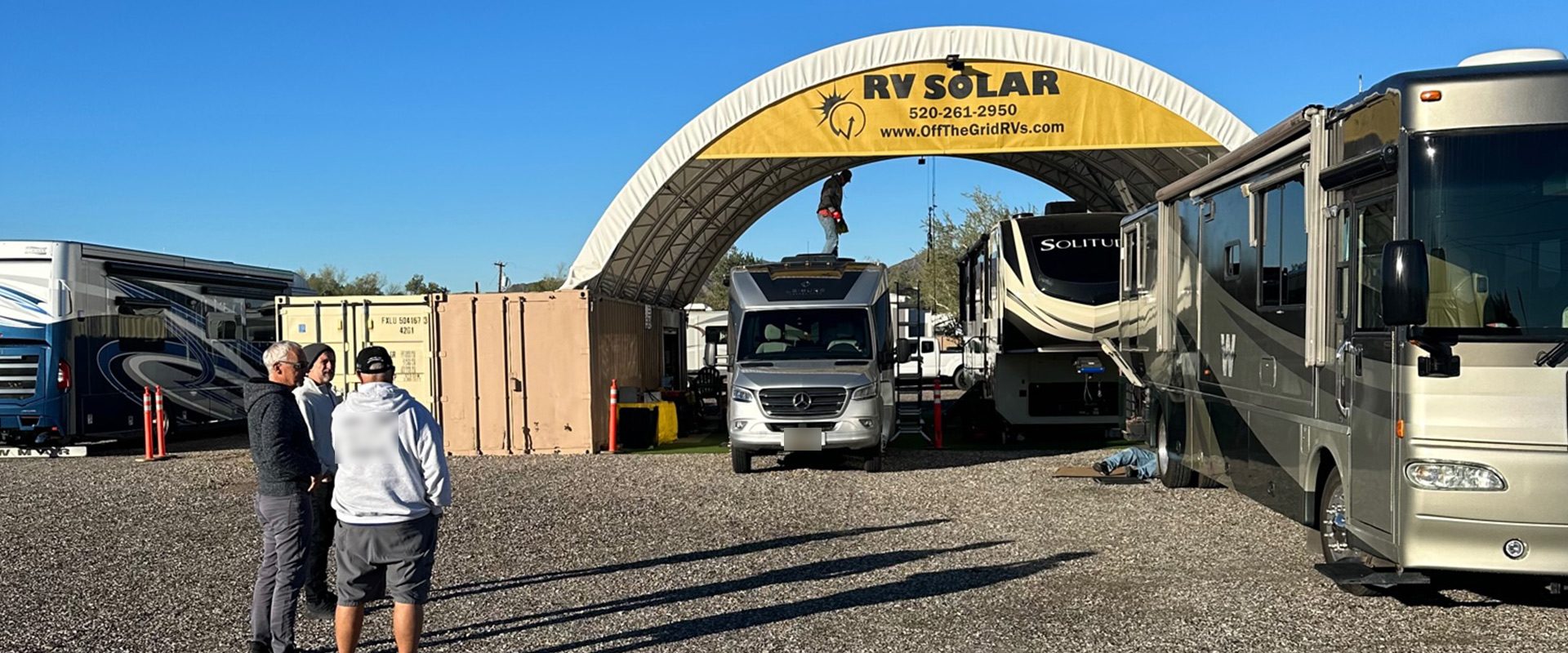 RVs lined up under the OffTheGridRVs RV Solar canopy at the shop on Hwy 95 in Quartzsite, Arizona