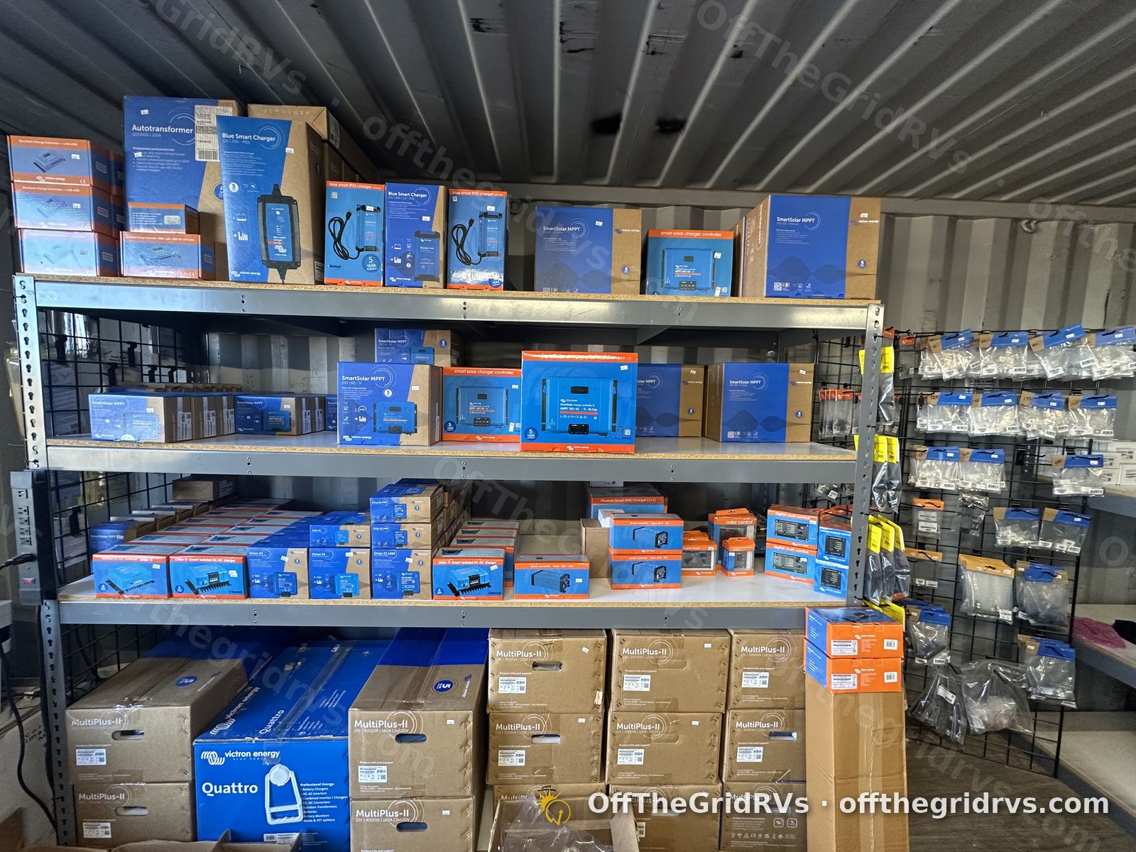 Showroom wall of Victron Energy Blue Smart chargers, SmartSolar MPPT charge controllers, an autotransformer and boxed MultiPlus-II and Quattro inverter/chargers